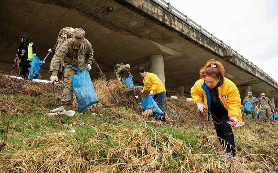 U.S. soldiers from Camp Casey and local volunteers clean up debris along the Shincheon River in Dongducheon, South Korea, Thursday, March 21, 2019.