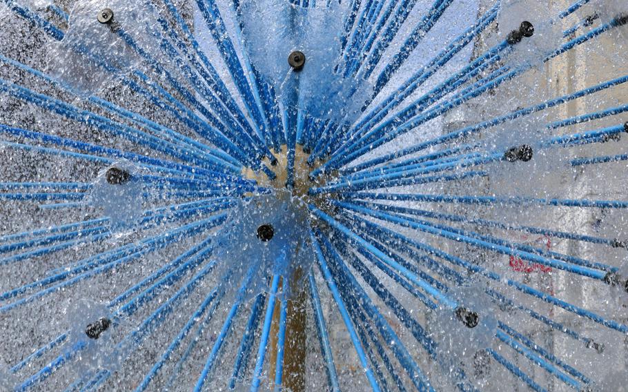 A modern fountain on the opposite end of Place Drouet D'Erlon from the Sube fountain in Reims, France. This one, spraying jets of water, reminds one perhaps of a dandelion.