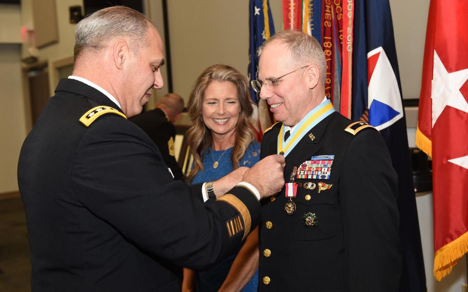 Maj. Gen. Allan Elliott receives honors at his March 28, 2019, retirement from Army Materiel Command Gen. Gus Perna, who officiated at the ceremony. The Army may need to pay a larger midcareer incentive to retain officers under the newly introduced blended retirement system, according to a Rand Corp. report.