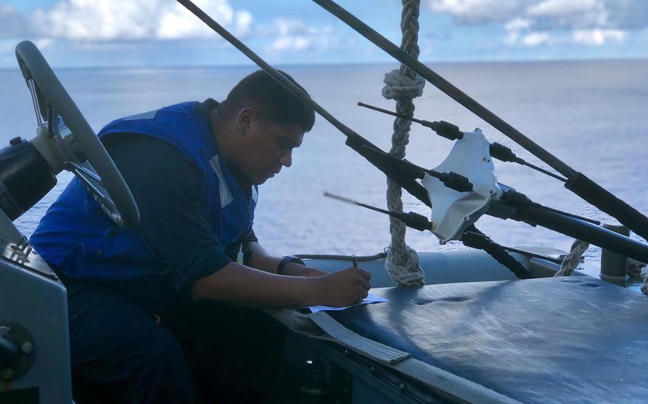 A sailor works aboard the USS Antietam guided-missile cruiser during a Pacific Vanguard drill near Guam, Friday, May 24, 2019.