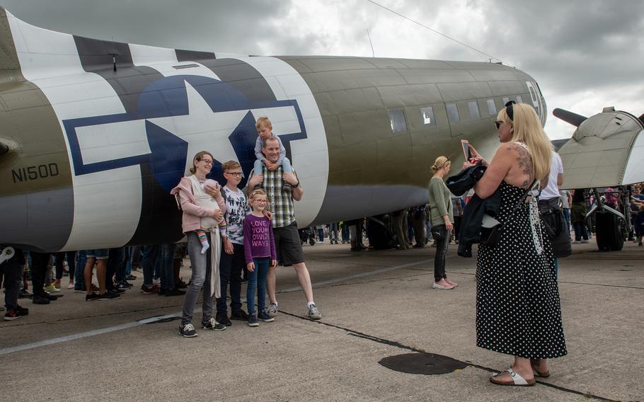 A family poses for a portrait in front of a C-47 Skytrain during the 70th anniversary commemoration of the end of the Berlin Airlift at Clay Kaserne airfield, Monday, June 10, 2019. 