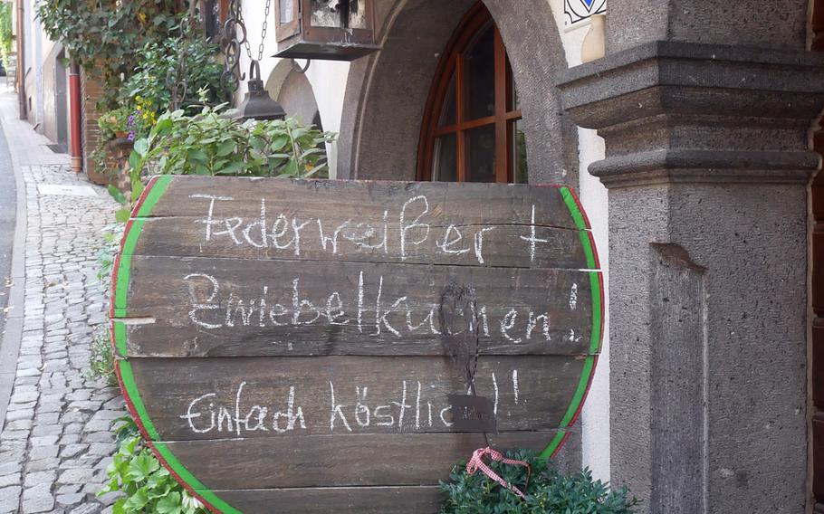 A sign in front of a wine tavern in Cochem, Germany, announces it offers Federweisser and Zwiebelkuchen. The former is a partially fermented young wine, while the latter is an onion tart. They are traditionally served in the autumn during the grape harvest season.