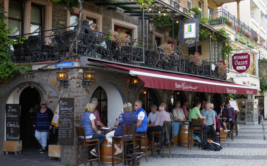 Visitors to Cochem, Germany, taste the wine at wine tavern near the Moselle River.