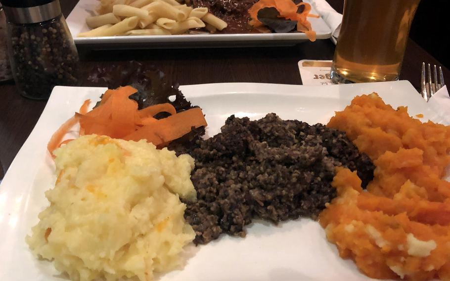 Haggis with neeps and tatties (yellow turnips and potatoes), foreground and beef goulash with noodles, as served at Scotch N Soda gastropub in Wiesbaden, Germany.