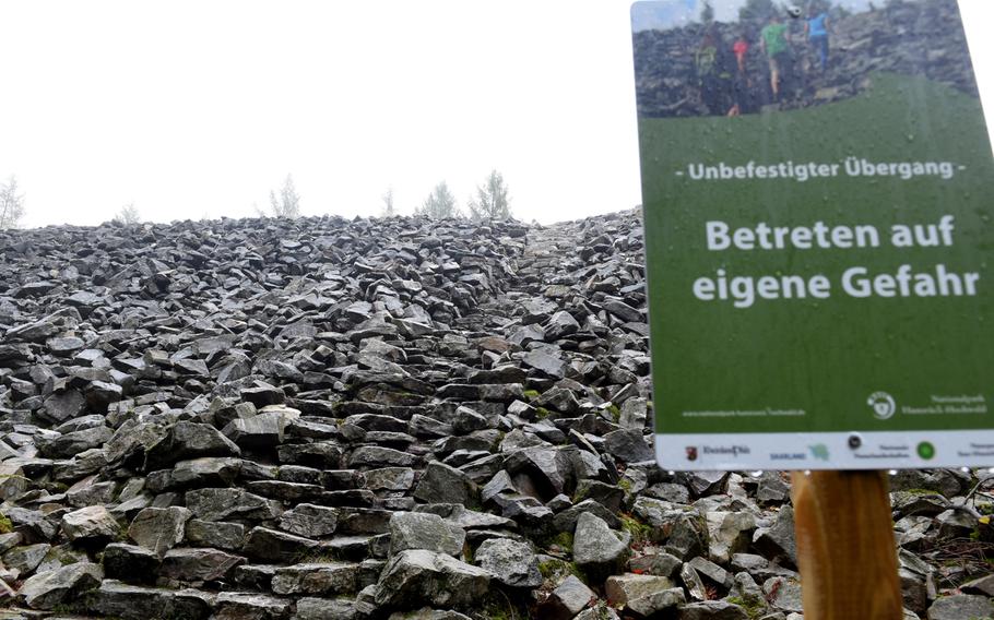 Stone stairs and an "enter at your own risk" warning greet hikers on top of the northern side of the Celtic ring wall in Otzenhausen, Germany.