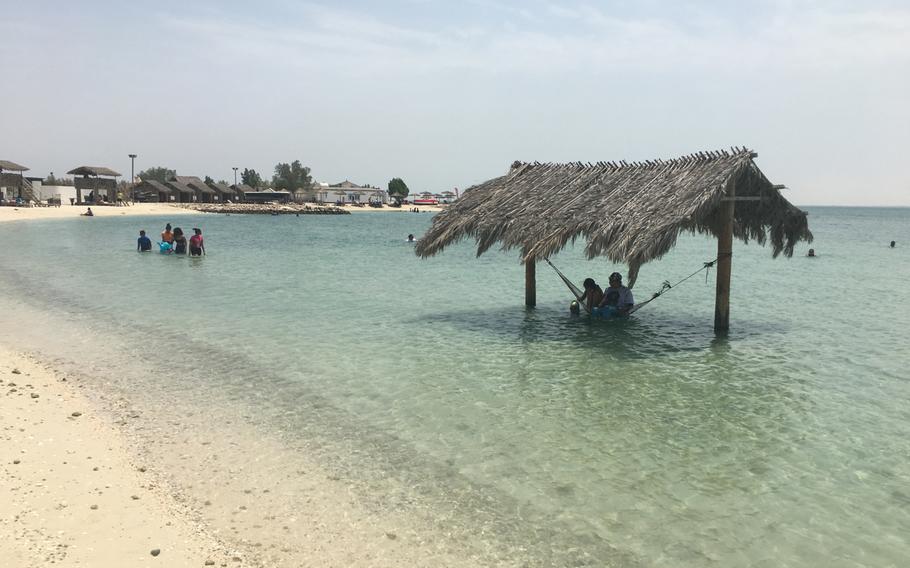 Visitors swim and relax in the shade at Al Dar Island.