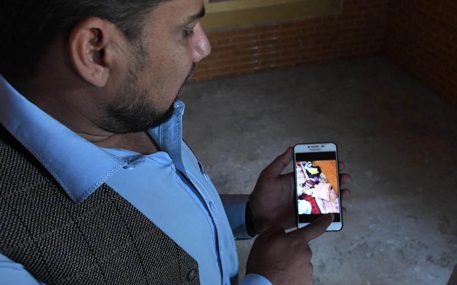 Mohammad Ibrahim on Sunday, Oct. 27, 2019, shows photos on his mobile phone of the night he found his four nephews shot dead at their home in Jalalabad.