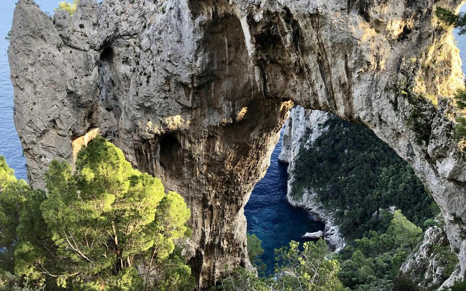 View from behind Arco Naturale, a rock formation on Capri's southern cliffs, overlooking the Mediterranean Sea.