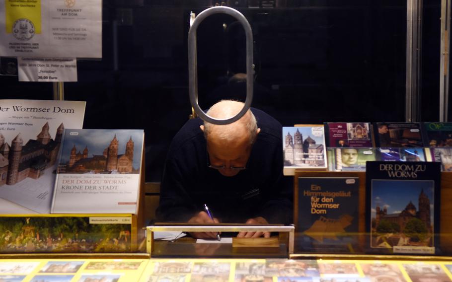 A man works behind an information booth inside St. Peter's Cathedral in Worms, Germany.
