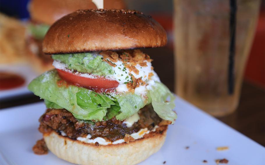 The Mexican Taco Burger from Captain Kangaroo on Okinawa features a chunky beef patty, melted cheese, guacamole, tomato, sour cream and chili beans.
