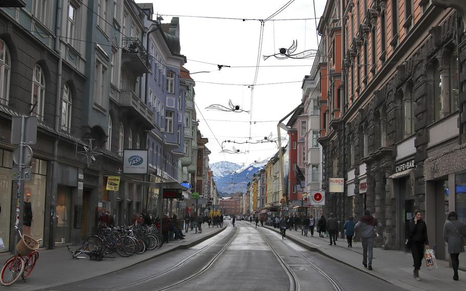 A street view of Innsbruck's colorful city center. No matter which way you look, you will see mountains in the distance as the city is surrounded by the Alps.