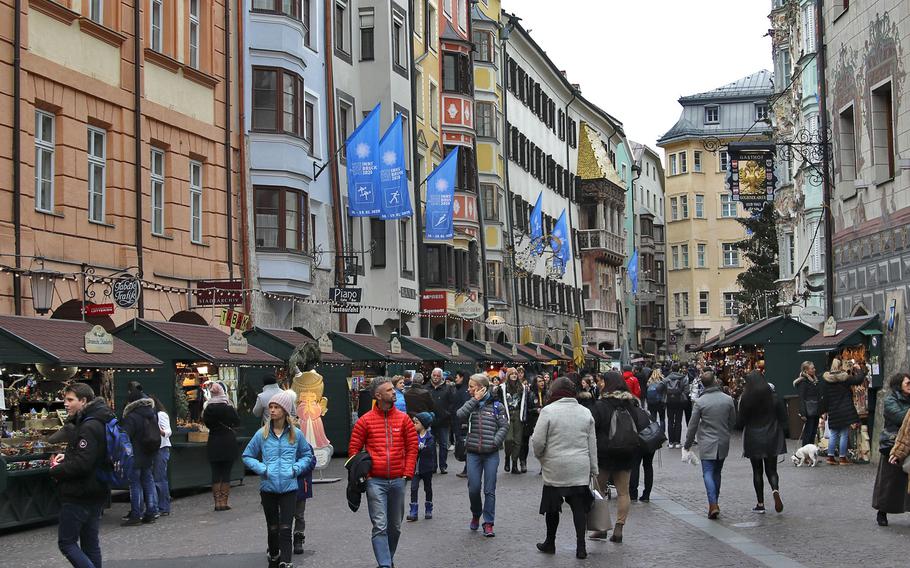 Innsbruck's bustling city center with Christmas markets in full swing. The colorful city is located in a valley that's completely surrounded by the Alps.