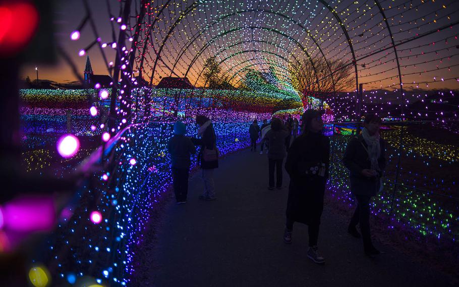 Visitors stroll through a rainbow light tunnel at Tokyo German Village, a theme park in Chiba prefecture, Japan.  