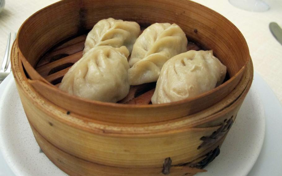 Steamed dumplings at Cicchetteria Cinese Zhu, Vicenza's new Chinese restaurant, arrives hot and pillowy in a wood bowl.