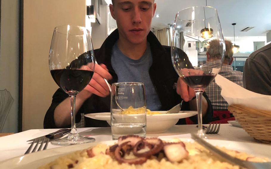 In the foreground, risotto with octopus, and in the background, a diner tucks into pasta prepared in a wheel of parmesan at Italiano Sapori Veri in Kaiserslautern, Germany.