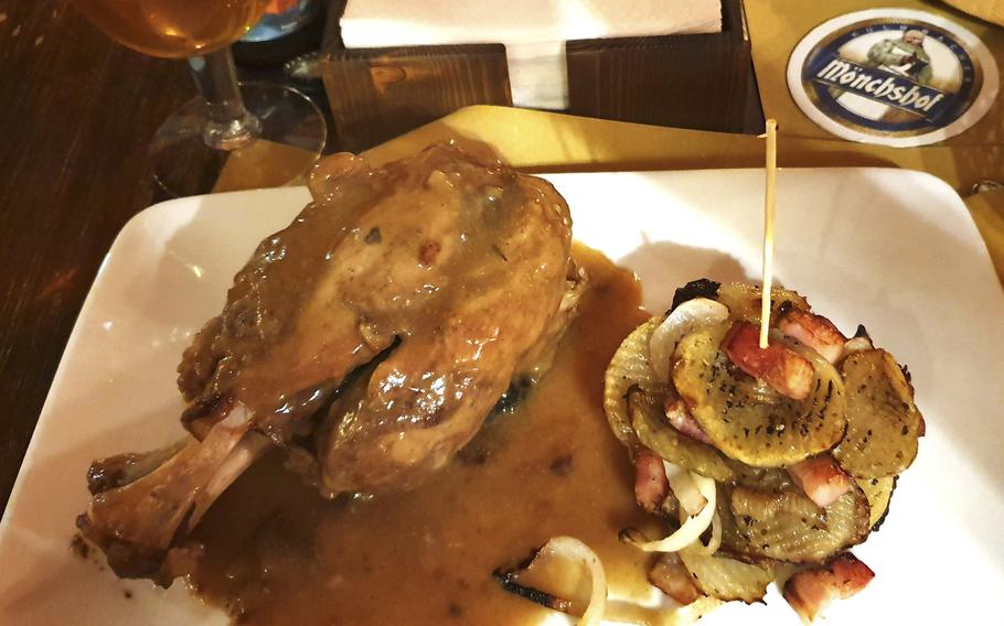 The pork shank braised in German red bock beer is served with a side of roast potatoes, bacon and onions at the German Pub and Alehouse in Sacile, Italy.