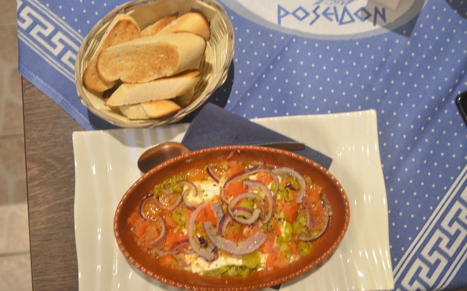 Saganaki pikant is a slice of feta cheese baked with peppers, tomatoes, garlic and onions served with toasted bread.