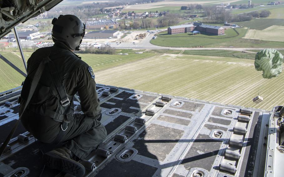 Tech. Sgt. Alex Carlson, a 37th Airlift Squadron loadmaster, pushes an airdrop package out over Chievres Air Base, Belgium, March 26, 2020.