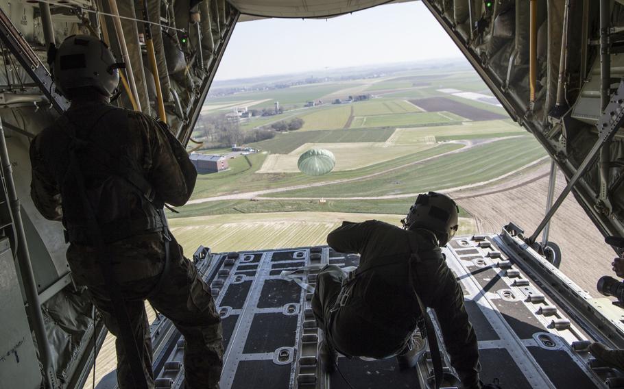 Air Force Staff Sgt. Brian Clark and Tech. Sgt. Alex Carlson, 37th Airlift Squadron loadmasters, push an airdrop package out over Chievres Air Base, Belgium, on March 26, 2020.