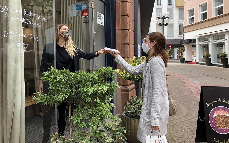A customer picks up a slice of cake she ordered from the new online shop at Cafe Susann in Kaiserslautern, Germany. The cafe shut down for a week to allow staff to brainstorm what changes to make to survive the coronavirus pandemic, which has hit restaurants particularly hard.
