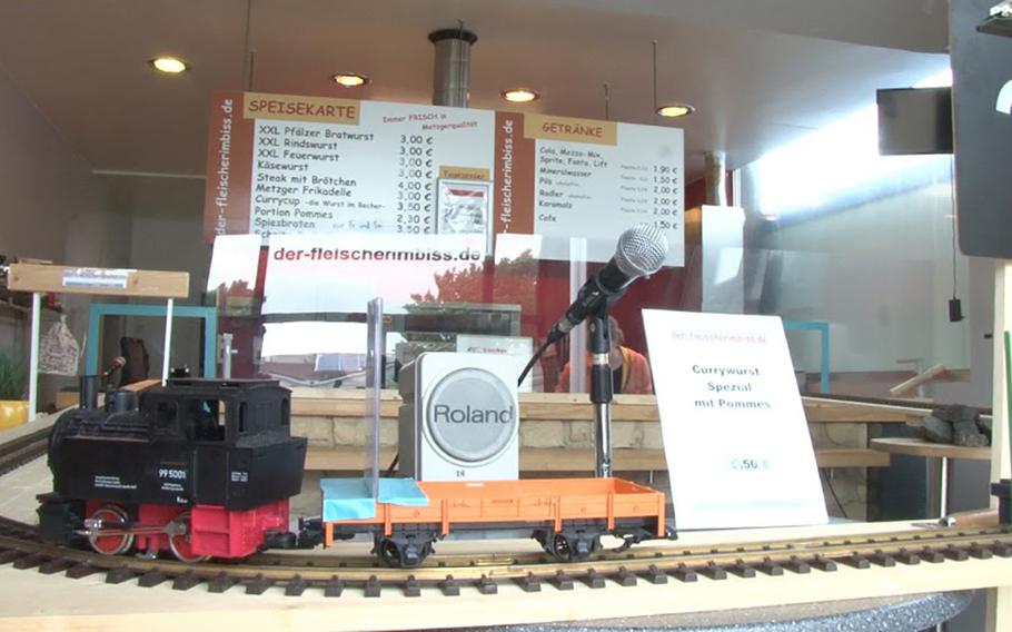 One of two large-gauge model train at the Fleischerimbiss in Kirchheimbolanden, Germany, carries their payments up a track to the cashier behind a plexiglass barrier. The owner of the snack bar, Mario Ludwig, installed the trains to allow him and his staff to maintain social distancing while serving food to customers. 
