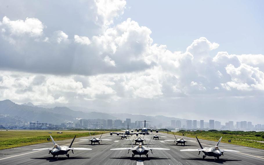Eight U.S. Air Force F-22 Raptors, a KC-135 Stratotanker and a C-17 Globemaster III taxi on the runway during routine training April 21, 2020, at Honolulu International Airport, Hawaii.
