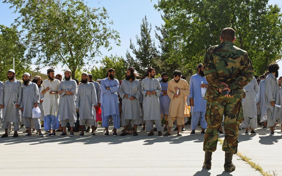 An Afghan soldier keeps an eye on Taliban prisoners before their release from Bagram prison in May 2020. The Taliban have maintained close ties with al-Qaida despite striking a deal with the U.S. that would require them to disavow the group in exchange for a U.S. troop withdrawal, the Defense Department said. 