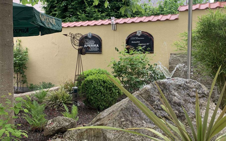 At the restaurant Zum Stich'n, there is a fountain with plants that makes for a pleasant dining experience in Grafenwoehr, Germany.