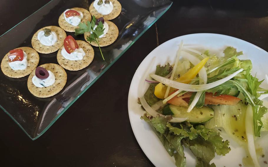 The tzatziki, left, from Shupoul in Tachikawa, Japan, consists of six crackers with a dollop of the Greek yogurt and cucumber sauce, each with a caper, kalamata olive slice or chunk of cherry tomato. 