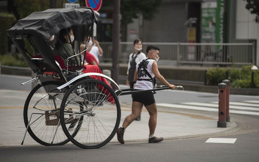A rickshaw driver gives a tour of Asakusa, an old district of Tokyo known for the Sensoji Buddhist temple, Sept. 1, 2020.
