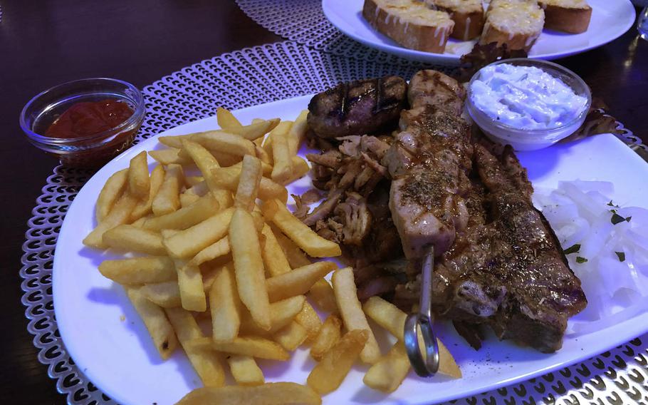 The Rhodos plate at Asteria includes gyro meat, soutzoukaki, lamb chops, souflaki, tzatziki, fries and a salad.