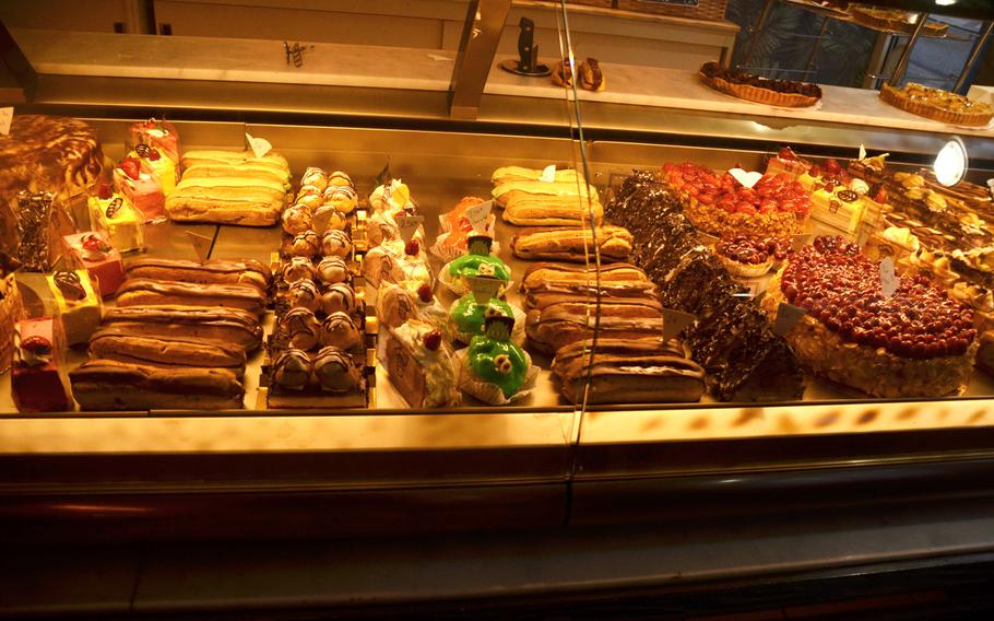 An array of pastries and cakes, including chocolate eclairs and fruit tarts, feature in the display case at Patisserie Antoine in Bitche, France, on Oct. 10, 2020. Pastries can be eaten at the cafe or taken home.