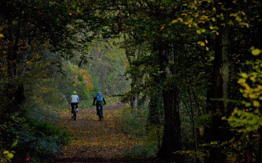 A couple on mountain bikes rides back to the starting point of the Alter Grenzweg trail in Berus, Germany. The lightly trafficked trail crisscrosses in and out of France.