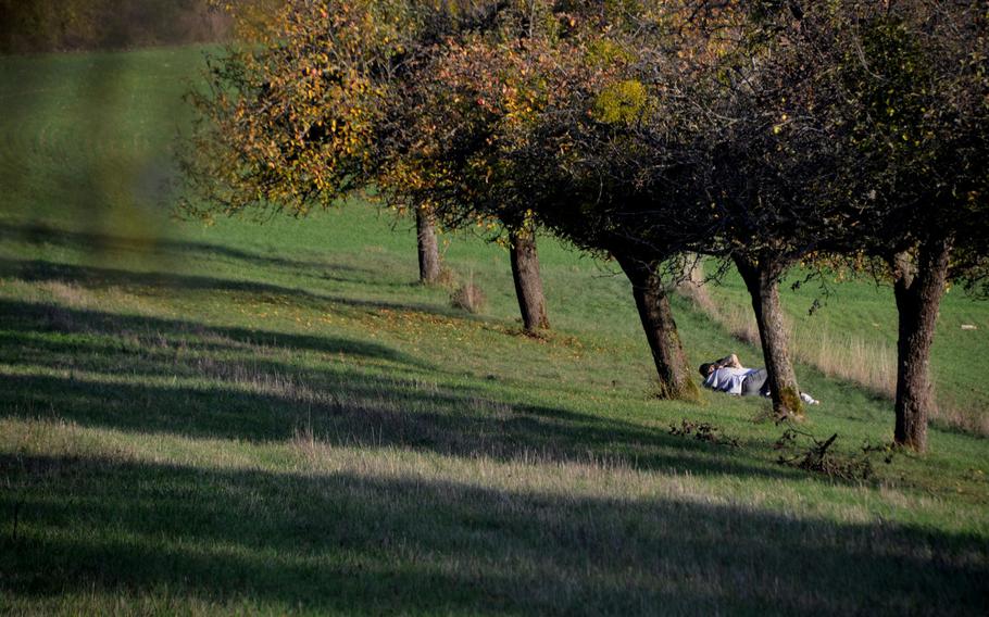 A couple shares a moment under trees near the Alter Grenzweg trail that crisscrosses the German-French border near the town of Berus, Germany. Most people who were walking the lightly trafficked trail on Oct. 30, 2020 respected social distancing rules.
