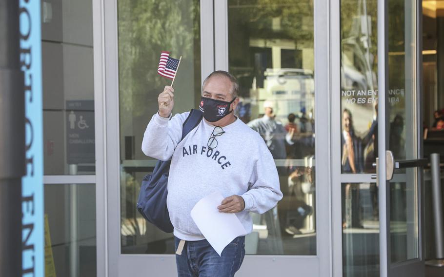 Robert Vivar waves a U.S. flag as he enters the United States at the San Ysidro Port of Entry on Thursday, Nov. 11, 2021 in San Diego, CA. Vivar who runs a support organization for deported veterans and a deportee himself, was allowed back into the US on Veterans Day. 