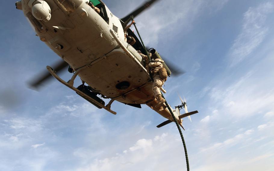 A Marine rappels from a UH-1Y Venom during a fast-rope training exercise through Weapons Tactics and Instructors course on the outskirts of Marine Corps Air Station Yuma, Ariz., April 4, 2015.