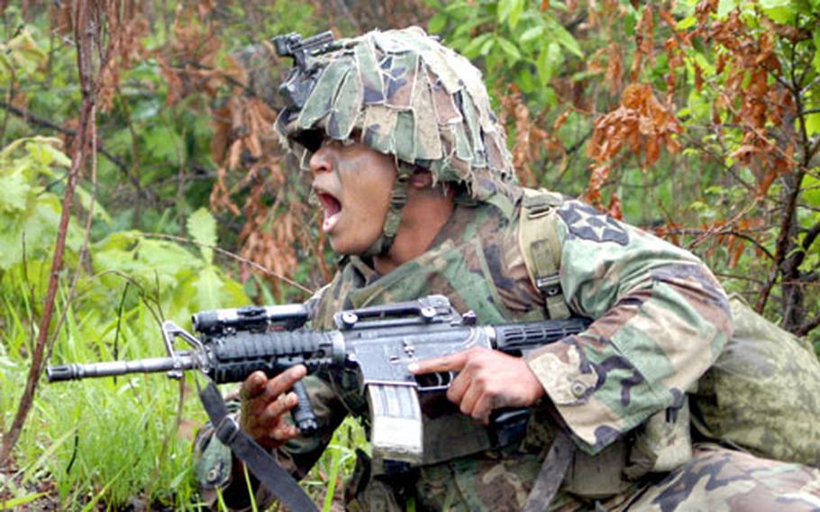A soldier from D Company, 2nd Battalion, 9th Infantry Regiment watches a smoke grenade he has just thrown explode on Objective Niner.
