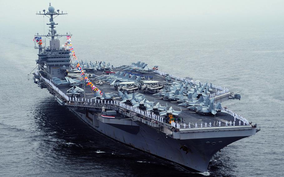 Sailors man the rails aboard the aircraft carrier USS George Washington as the ship pulls into port at Yokosuka, Japan, to celebrate the 4th of July.