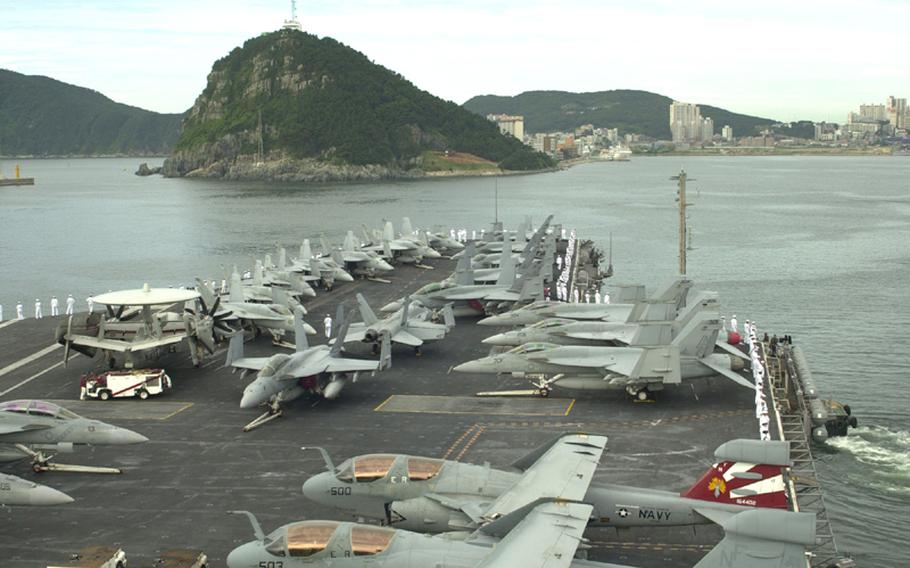 The USS George Washington pulls away from Pusan in South Korea on its way Sunday to participate in the Invincible Spirit joint military exercise being staged for four days by the U.S. and South Korea.