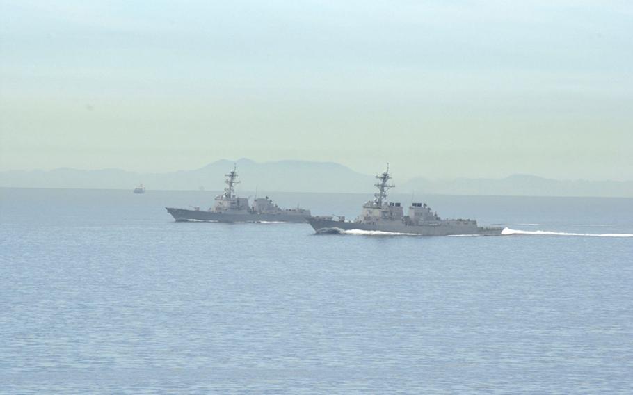 Two U.S. destroyers proceed alongside the USS George Washington on Sunday during the Invincible Spirit exercise off the coast of South Korea.