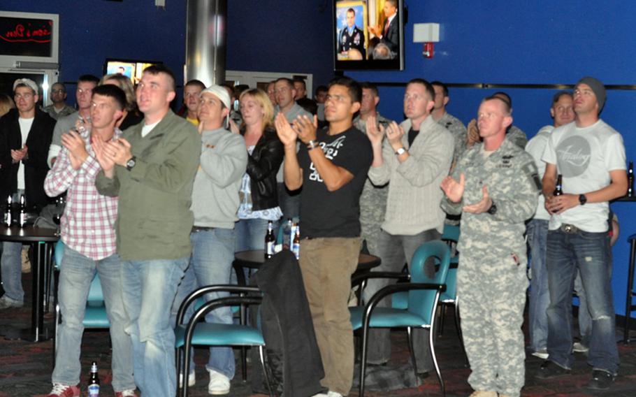 Soldiers from the 173rd Airborne Brigade, many dressed in civilian clothes after returning from a recent rotation in Afghanistan, cheer as they watch the Medal of Honor ceremony Tuesday at Caserma Ederle in Vicenza, Italy.