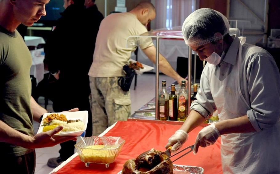 Marine Cpl. Adam Powell, 24, of Greenville, S.C., waits for some turkey Thursday night at the Adraskan National Training Center in western Afghanistan. Fifteen Marines celebrated the holiday here in the midst of a deployment where they are training Afghan police.