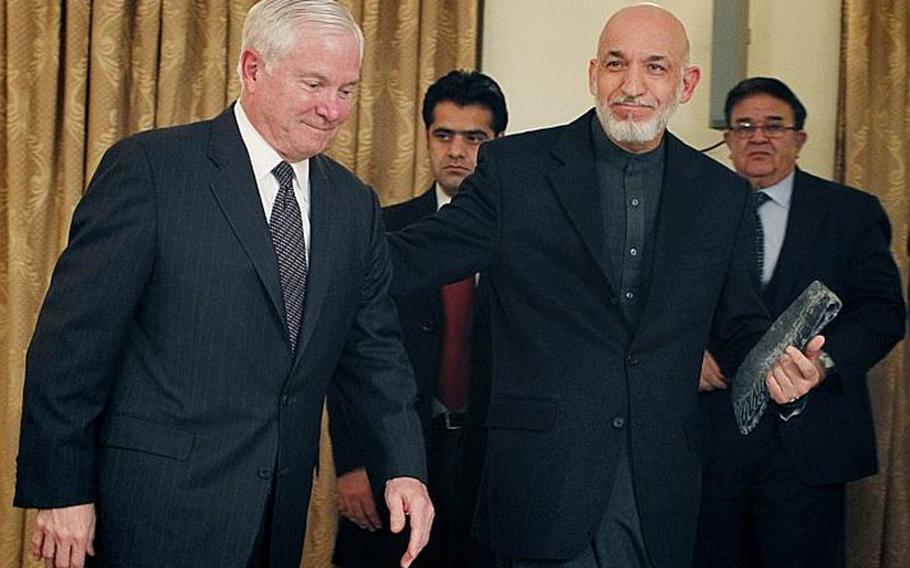 In this file photo, Defense Secretary Robert Gates is escorted by Afghan President Hamid Karzai after a joint press conference at the presidential palace in Kabul during a past visit.