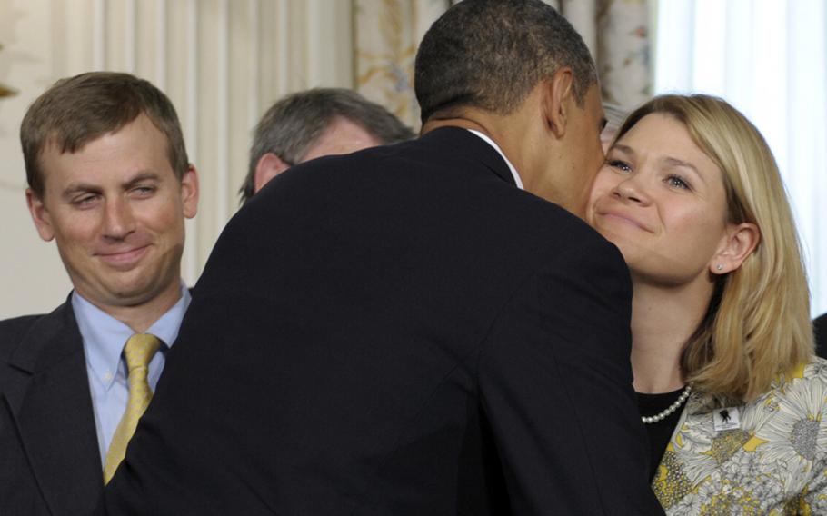 In 2010 file photo, President Obama gives Sarah Wade, wife of Army Sgt. Ted Wade, left, a kiss on the cheek before he signed the Caregivers and Veterans Omnibus Health Services Act..
