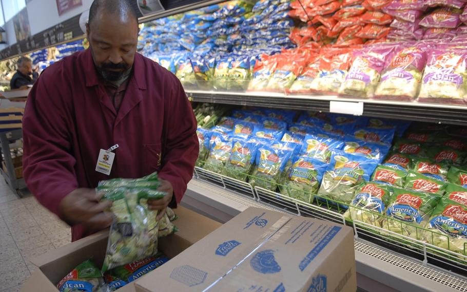 Garry Briggs unpacks a box containing bags of lettuce Wednesday at the commissary at Ramstein Air Base, Germany. The Defense Commissary Agency Europe tripled its supply of bagged lettuce from the States during the current E. coli outbreak. 