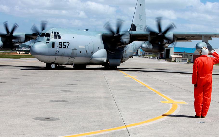 Lance Cpl. Jamaal Smith, a Bakersfield, Calif. native and freight clerk for Headquarters and Headquarters Squadron, Marine Corps Air Station Futenma, salutes as a KC-130J Super Hercules cargo aircraft prepares to leave the air station en route to mainland Japan in support of Operation Tomodachi March 18, 2011.