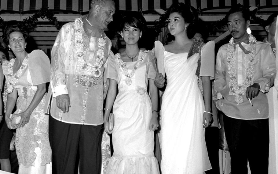 President Lyndon Johnson and South Vietnamese Prime Minister Nguyen Cao Ky attend a local ceremony during the seven-nation Manila Summit. With them are Ky's wife, Dang Tuyet Mai Ky, second from left, and Philippine first lady Imelda Marcos. In the background at left is Lady Bird Johnson.