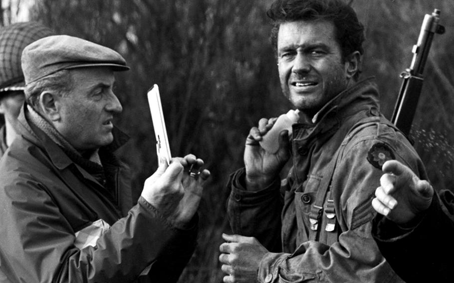 A makeup man holds up a mirror as Cliff Robertson squirts on some fake sweat on the set of "Up from the Beach."