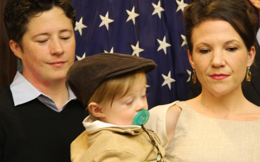Army National Guard Maj. Shannon McLaughlin (left) and her spouse, Casey, take care of their 10-month-old son, Grant. The couple has been legally married for three years, but federal laws prohibit Casey from receiving any housing or health benefits from the military.
