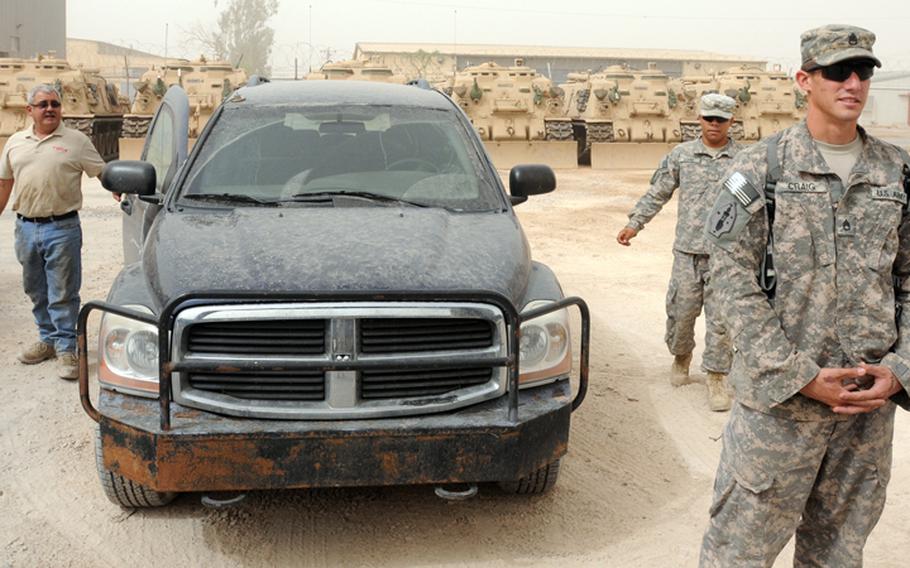 Staff Sgt. Matthew Craig, from Headquarters and Headquarters Company, 4th Brigade Special Troops Battalion, 4th Advise and Assist Brigade, 1st Armored Division, escorts a contractor to the Iraqi army side of Contingency Operating Base Taji, Iraq, Oct. 1, 2011. Soldiers with HHC were providing security for civilian contractors working with Iraqi army personnel as U.S. forces continue to transition out of Iraq.